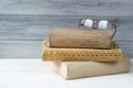 Stack of old books and reading glasses on wooden background Royalty Free Stock Photo