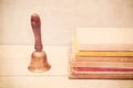 A stack of old books and a school call vintage. Education concept Royalty Free Stock Photo