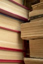 A stack of old books shooting up close. Old paper in books - a large stack - vertical photo. Ancient books in a stack.