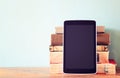 Stack of old books and tablet over wooden shelf. new technology concept. room for text. Royalty Free Stock Photo