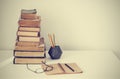 Stack of old books, textbook, glasses and pencils in office background for education retro concept