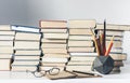 Stack of old books, textbook, notebook, glasses and pencils on white table in office background for education concept Royalty Free Stock Photo