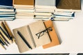 Stack of old books, textbook, notebook, glasses and pencils on white table in office background for education concept Royalty Free Stock Photo