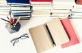 Stack of old books, textbook, notebook, glasses and pencils on white table in office background for education concept Royalty Free Stock Photo