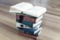 Stack of old books on wooden background. Opened book above. Royalty Free Stock Photo