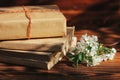 a stack of old books on a wooden background with a sprig of a flowering tree. the concept of memorabilia