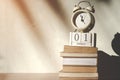 Stack old books with wooden calendar and vintage alarm clock Royalty Free Stock Photo