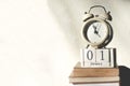 Stack old books with wooden calendar and vintage alarm clock table in sunlight morning Royalty Free Stock Photo