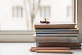 A stack of old different books and several colored pencils lie on the windowsill, a couple of pieces of chocolate lying on the Royalty Free Stock Photo