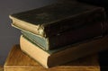 STACK OF OLD GREEN SHADED BOOKS ON A WOODEN CRATE