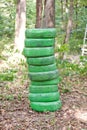 Stack of old green tires in the forest Royalty Free Stock Photo