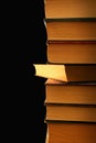 Stack of old hardcover books in the dark, with one slightly pulled out Royalty Free Stock Photo