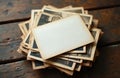 Stack of old photos and postcards rests on a rustic wooden table. Blank space on top photo allows for custom text or images. A Royalty Free Stock Photo