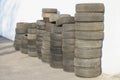 A stack of old tires near a white wall. Royalty Free Stock Photo