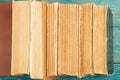 Stack of old and used hardback books or text books on blue wooden background Royalty Free Stock Photo