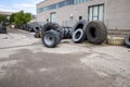 Stack of old used tires of different sizes and types in abandoned scrap yard.