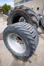 Stack of old used tires of different sizes and types in abandoned scrap yard.