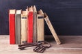 Stack of old vintage books and a bunch of old big iron keys lie on wooden table. Royalty Free Stock Photo