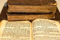 Stack of old and worn leather cover books with gold leaf embossing