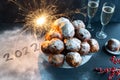 A stack of oliebollen (Dutch dough fritters) with the year 2022 written in icing sugar