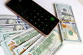 A stack of one hundred dollar bills and a calculator on a smartphone. Royalty Free Stock Photo