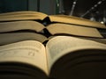 Stack of open book and two page open book on the front in library.