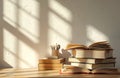 Stack of open and closed books on wooden desk near pen holder. Soft sun light creates shadow patterns on wall. Study or library Royalty Free Stock Photo