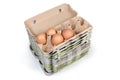 Stack of open empty egg cartons with several chicken eggs