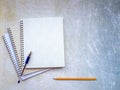 A stack of open notebooks. The handle is on top. Pencil at the bottom of the background.
