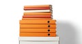 Stack of orange binders and books on a white surface Royalty Free Stock Photo
