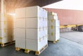 Stack of Package Boxes on Pallets Load with Shipping Cargo Container. Truck Parked Loading at Dock Warehouse. Delivery. Royalty Free Stock Photo