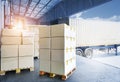 Stack of Package Boxes on Pallets Loading into Shipping Cargo Container. Truck Parked Loading at Dock Warehouse. Supply Chain.