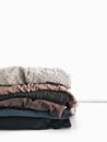 Stack of pale faded colors clothes on white background. Copyspace. For fashion bloggers, style magazines, instagram