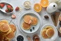 A stack of pancake with blueberries, strawberries, orange on white marble table. Breakfast menu.