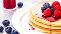 Stack of Pancakes with berry jam and fresh berries, served on a plate on the table