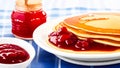 Stack of Pancakes with berry jam and fresh berries, served on a plate on the table