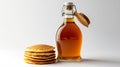 A stack of pancakes with a bottle of maple syrup on a white background Royalty Free Stock Photo