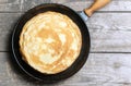 Stack of pancakes on a cast-iron frying pan.