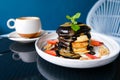 stack of pancakes with chocolate syrup, caramel and strawberries and cup of coffee. Royalty Free Stock Photo