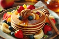 A stack pancakes with fruit and honey drizzled on top