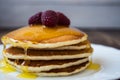 Stack of pancakes with honey and raspberry on white plate Royalty Free Stock Photo