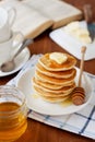 Stack of pancakes with honey syrup, butter and strawberry in a white plate Royalty Free Stock Photo