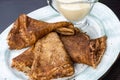 Stack of pancakes on a plate with sour cream. Traditional for the Russian pancake week. Dark background