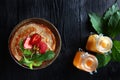 A stack of pancakes with strawberries and mint . Two jars of honey on the table. Photo on a black background. Copy of the space. Royalty Free Stock Photo