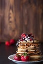 Stack of pancakes with strawberries, whip cream and chocolate syrup on a white plate on a wooden background. Royalty Free Stock Photo