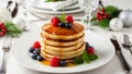 Stack of pancakes with syrup and berries on a blurred Christmas table setting background. Royalty Free Stock Photo