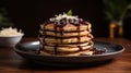 A stack of pancakes with a syrup and berry on black plate. Sweet pancake on a plate. Sweet dessert Royalty Free Stock Photo