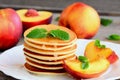 Stack of pancakes with syrup and grilled nectarines on a white plate. Easy sweet pancake recipe. Yummy breakfast or brunch Royalty Free Stock Photo