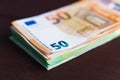 Stack of paper euro banknotes on wooden table. Heap of money. Selective focus. Close-up