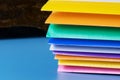 A row of multi-colored plastic folders for paper on a blue background